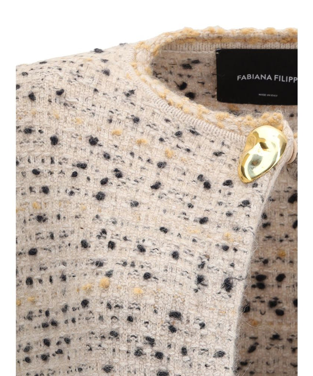 Close-up of Fabiana Filippi long knit jacket featuring gold-tone button closure and textured knit fabric detail near the collar.