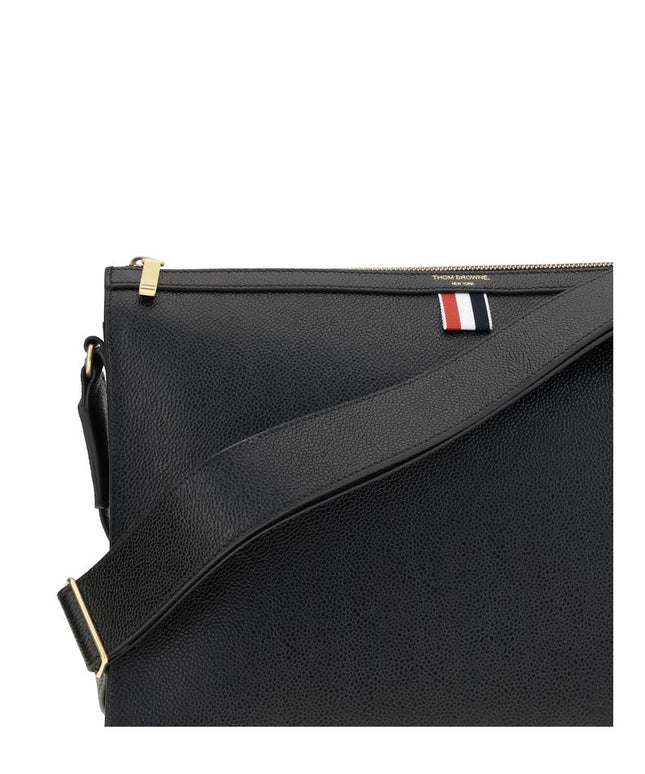 Close-up of Thom Browne Shoulder strap Pouch highlighting textured leather, adjustable strap, and tricolor tab for premium designer appeal.