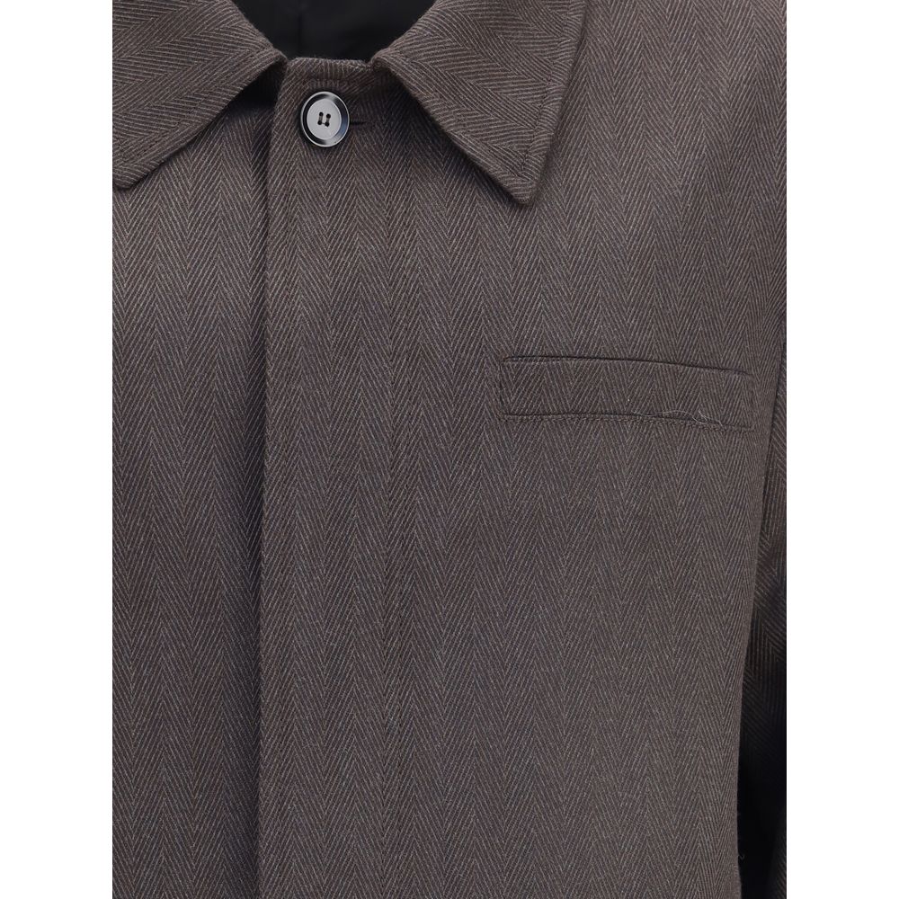 Close-up of Brioni Herringbone Jacket highlighting fine brown herringbone weave, button detail, and chest pocket stitching.