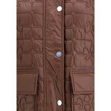 Close-up of Ganni Shiny Quilt Midi Jacket highlighting shiny quilted fabric, branded snap buttons, and front flap pockets. Premium detail for outerwear.