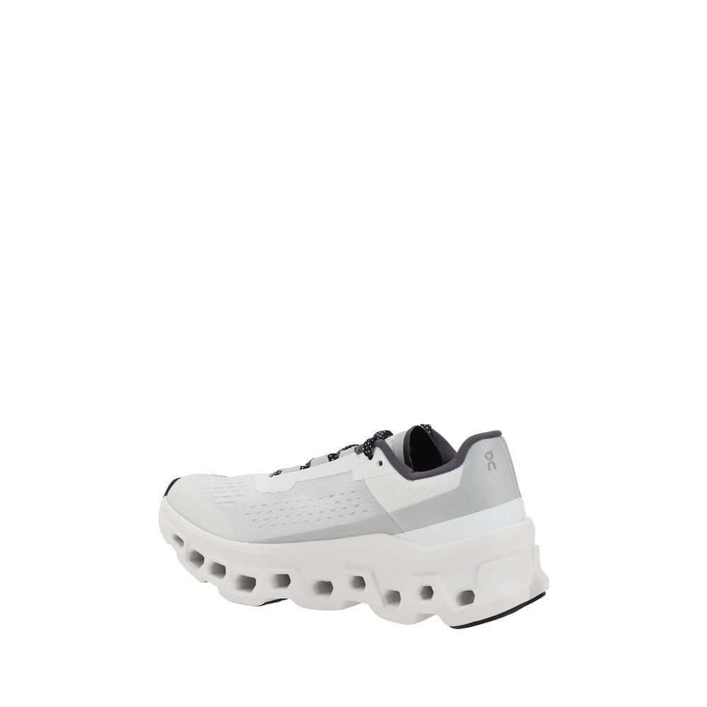 Rear view of ON Cloudmonster Sneakers highlighting heel support and aerodynamic design, white women's athletic shoes with black accents.