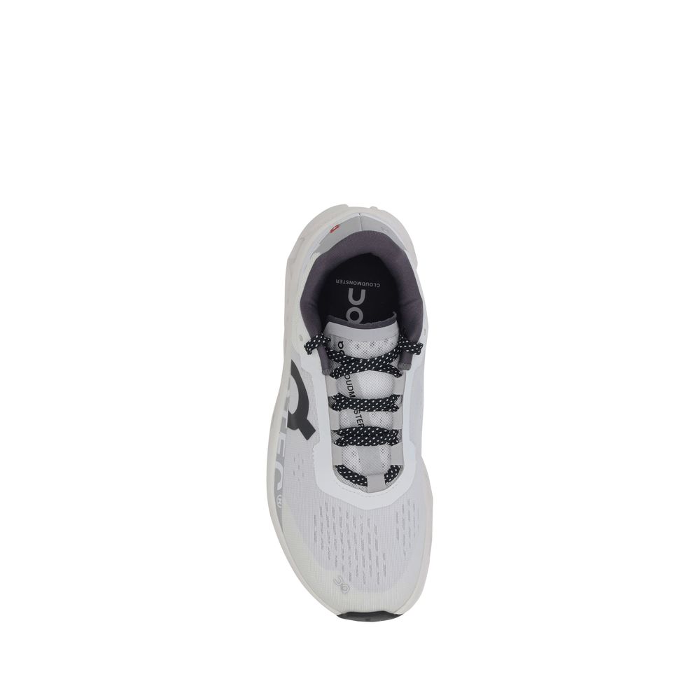 Top view of ON Cloudmonster Sneakers displaying black-and-white laces, padded collar, and breathable upper for women's athletic comfort.