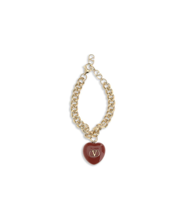 Valentino Garavani Coeur Royal chain bracelet featuring a gold-tone chain and red heart charm with signature V logo, ideal for luxury women's accessories.