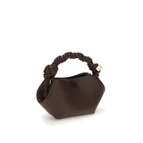 Side view of Ganni Grainy Bou mini Handbag showcasing its sculpted shape and knotted leather handle, perfect for stylish everyday use.