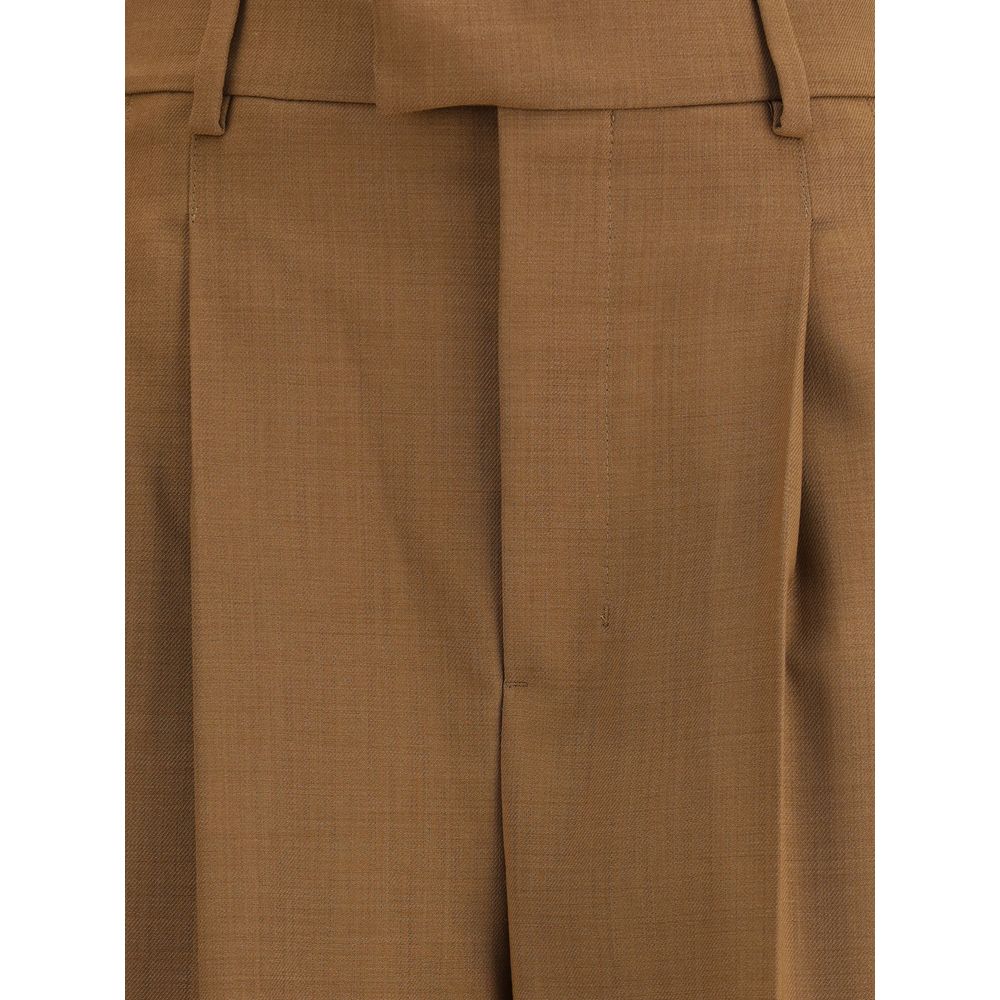 Close-up of Ami Paris High-waist trousers showcasing fine brown fabric texture and front pleat detailing for a refined finish.