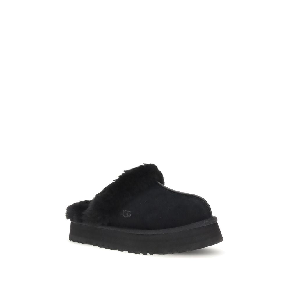 UGG Disquette Slides black women’s flats with elevated sole and cozy fur lining, angled front view ideal for casual comfort.