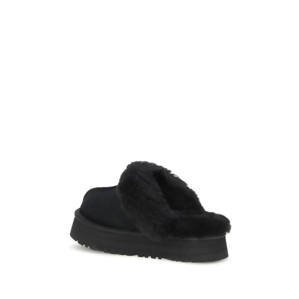 UGG Disquette Slides black slip-on shoes with thick sole and soft fur collar, rear angle showcasing heel and lining detail.