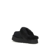 UGG Disquette Slides black slip-on shoes with thick sole and soft fur collar, rear angle showcasing heel and lining detail.