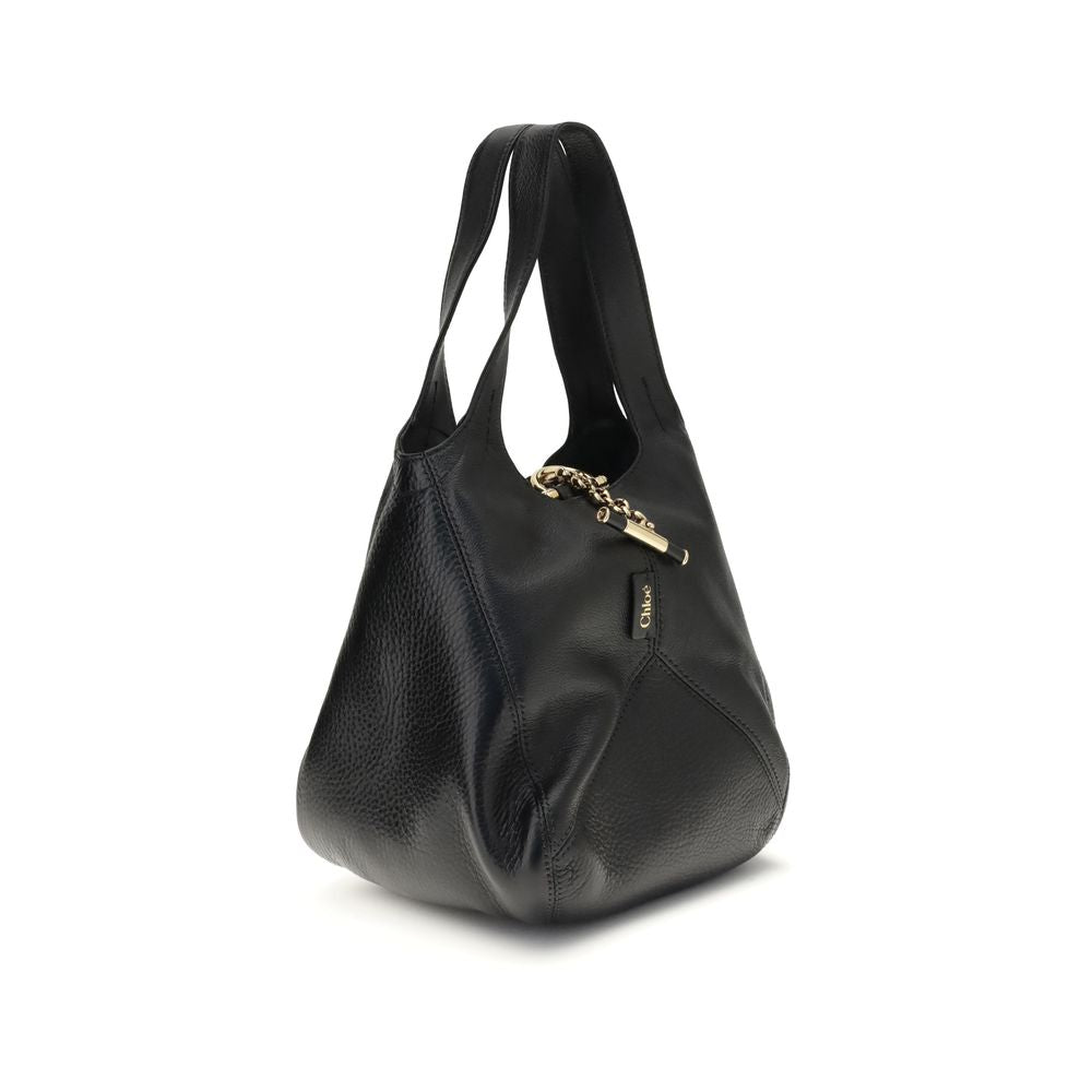 Side view of Chloé Small Balloon Shoulder Bag showcasing its soft black leather texture and elegant curved silhouette.