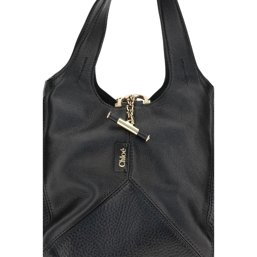 Close-up of Chloé Small Balloon Shoulder Bag featuring gold-tone chain detail and embossed Chloé logo on black leather.