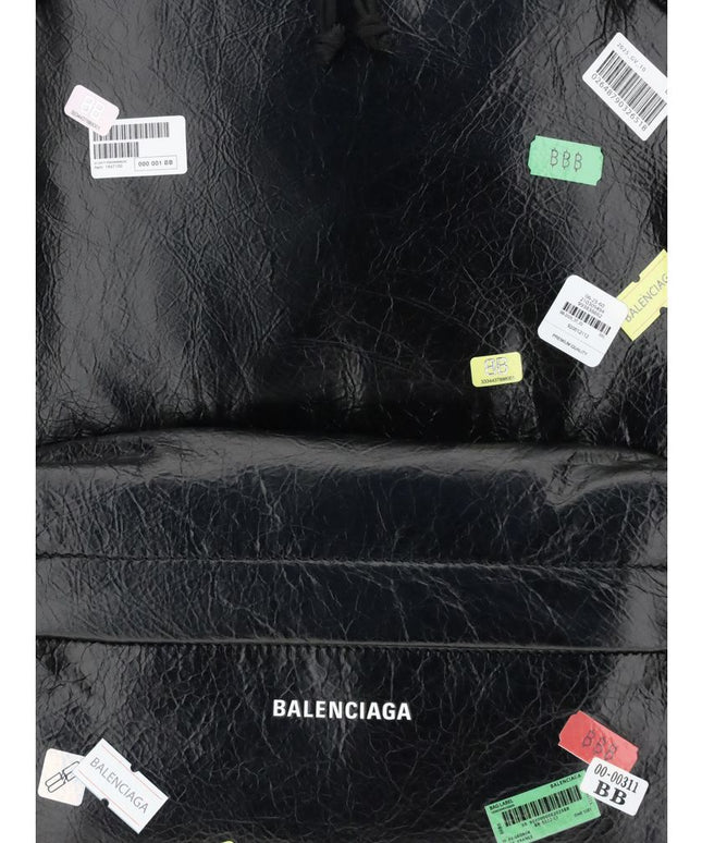 Close-up of Balenciaga Explorer Backpack showcasing printed sticker graphics and embossed logo, highlighting its designer streetwear appeal.