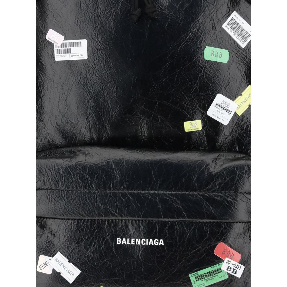 Close-up of Balenciaga Explorer Backpack showcasing printed sticker graphics and embossed logo, highlighting its designer streetwear appeal.