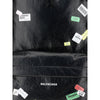 Close-up of Balenciaga Explorer Backpack showcasing printed sticker graphics and embossed logo, highlighting its designer streetwear appeal.